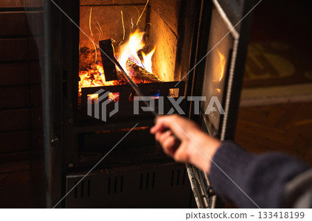 A woman uses the stove in the evening 133418199