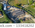 Aerial view of a sawmill factory uses renewable solar energy, with stacks of processed lumber and timber. 133418202