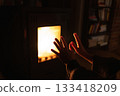 Close up of hands close to oven with glass window and fire inside. 133418209