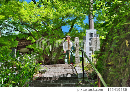 A boy walking up the approach to Sefukuji Temple 133419386