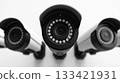 Group of modern security cameras mounted on a pristine white wall, featuring advanced electronic eyes providing vigilant digital observation and reliable indoor protection. 133421931