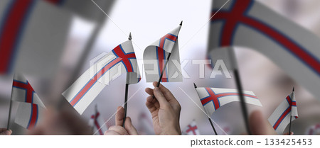 Faroe Islands flags in their hands on a blurred urban background 133425453