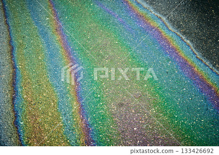 Rainbow iridescent oil slick spreading on wet asphalt 133426692