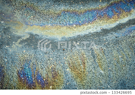 Dynamic fuel spill showing radiant colors that develop an abstract texture on the wet pavement 133426695