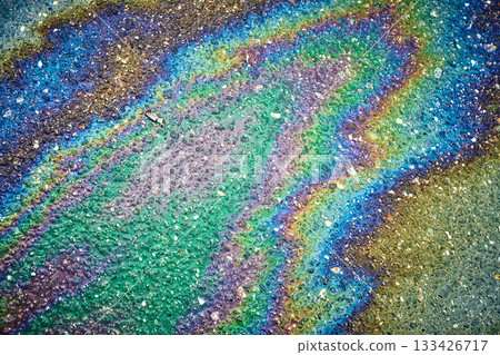 Wet asphalt surface displaying colorful iridescence from spilled oil creating an abstract pattern Wet asphalt surface displaying colorful iridescence from spilled oil creating an abstract pattern 133426717