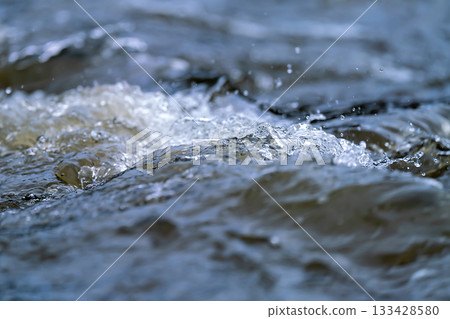 White splashes of water in a rapidly flowing river. White splashes of water in a rapidly flowing river. 133428580