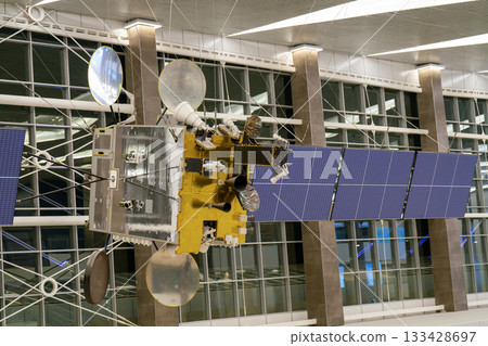 A model of a space satellite with solar panels. A model of a space satellite with solar panels. 133428697