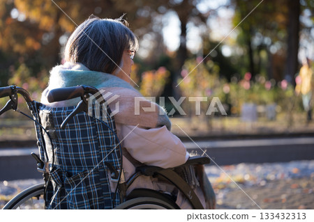 一位坐在輪椅上的老婦人抬頭微笑。 一位坐在輪椅上的老婦人抬頭微笑。 133432313