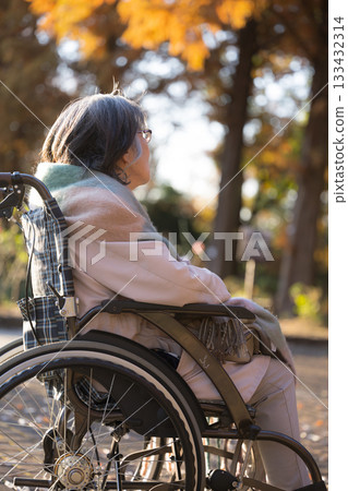 一位坐在輪椅上的老婦人抬頭微笑。 一位坐在輪椅上的老婦人抬頭微笑。 133432314