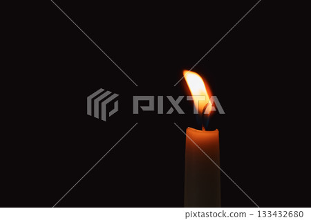 burning candle on black background 133432680