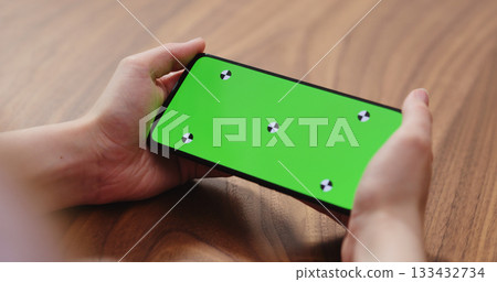 young woman holding smartphone over walnut table 133432734