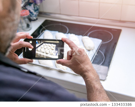 Man taking photo of homemade bread dough. Man taking photo of homemade bread dough. 133433386