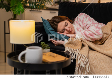 Adult woman exhausted after hard work day lies down on pillow closes eyes falls asleep at night calm 133433817
