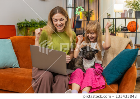 Mother daughter dog win game on laptop get positive test result celebrate good news smile together 133433848