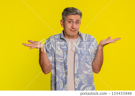 Adult man shrugging shoulders with confused expression raised hands showing he does not know answer Adult man shrugging shoulders with confused expression raised hands showing he does not know answer 133433946