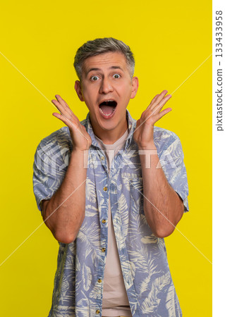 Adult man shocked with hands on cheeks mouth open in disbelief showing wow emotion strong surprise 133433958