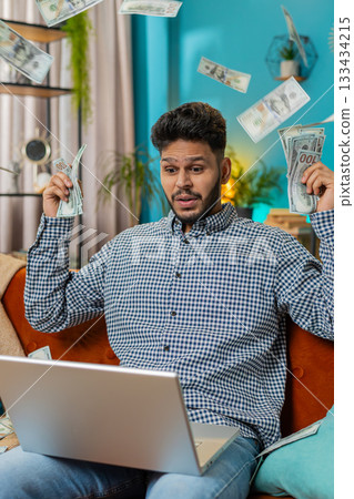 Money cash dollar rain falling on man celebrating success, winning good news, lottery jackpot luck 133434215