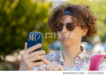 Happy tourist man using smartphone typing text messages browsing internet social media web app 133434260
