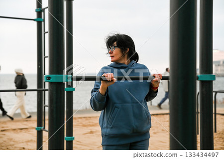 50 year old woman making vertical push ups outdoors 133434497