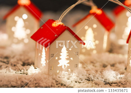 Glowing Christmas House string lights garland in snowy winter holiday atmosphere background 133435671
