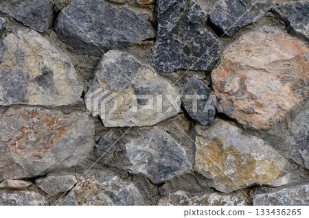 Natural stone wall brings rustic charm to outdoor garden space in sunlight Natural stone wall brings rustic charm to outdoor garden space in sunlight 133436265