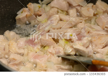 Delicious chicken being sauteed with onions in cozy kitchen during a late afternoon cooking session Delicious chicken being sauteed with onions in cozy kitchen during a late afternoon cooking session 133436303
