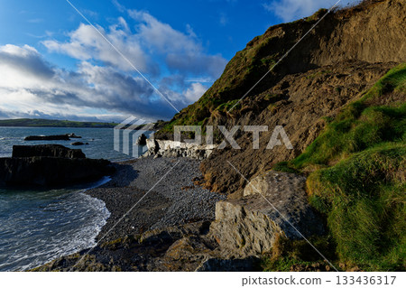 Pebble beach under green hill and blue sky perfect for a relaxing vacation. Pebble beach under green hill and blue sky perfect for a relaxing vacation. 133436317