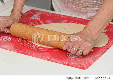 Rolling dough on a kitchen countertop while preparing for a delightful baking session with family and friends 133436693