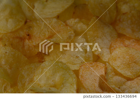 Crunchy potato chips create a tempting snack experience during a cozy movie night at home Crunchy potato chips create a tempting snack experience during a cozy movie night at home 133436694