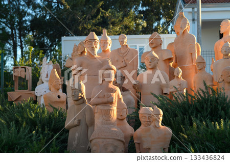 Stunning collection of terracotta sculptures displayed in serene outdoor setting during golden hour 133436824