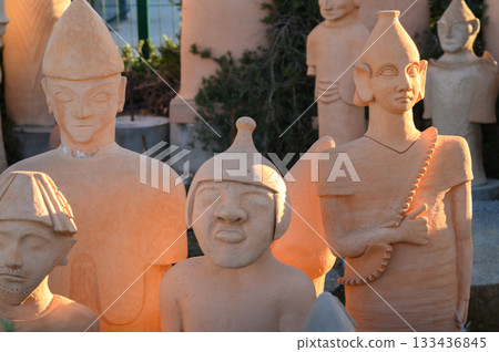 Timeless figures crafted from clay reflect the artistry of ancient cultures at a vibrant outdoor exhibit showcasing diverse sculptures 133436845