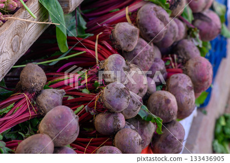 Colorful beets piled together at a vibrant farmers market in the late afternoon sun Colorful beets piled together at a vibrant farmers market in the late afternoon sun 133436905