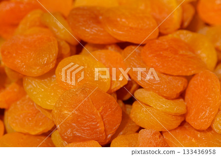 Dried apricots arranged in a colorful display showcasing their vibrant hues and natural texture during an artisanal market event Dried apricots arranged in a colorful display showcasing their vibrant hues and natural texture during an artisanal market event 133436958