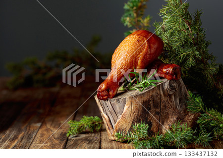 Smoked chicken drumsticks and juniper branches on a wooden table. Smoked chicken drumsticks and juniper branches on a wooden table. 133437132
