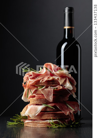 Spanish jamon or Italian prosciutto with bread, rosemary, and red wine. 133437138