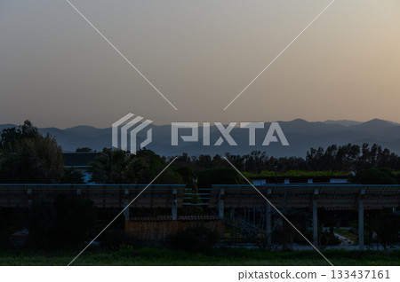 Tranquil twilight landscape with hazy mountains and serene stillness at dusk in a rural setting 133437161