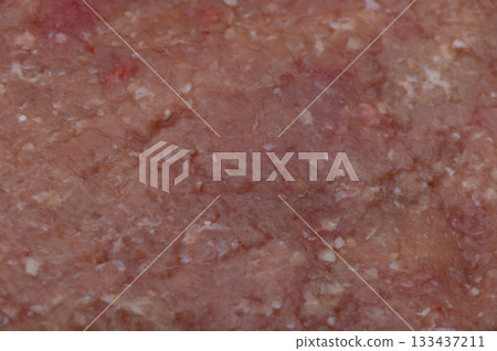 Richly textured ground meat displayed on a cutting board in a cozy kitchen setting during afternoon preparation 133437211