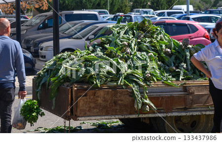Bountiful harvest of fresh greens at a bustling market during midday Bountiful harvest of fresh greens at a bustling market during midday 133437986