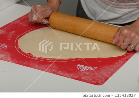 Rolling dough with care on a vibrant work surface during a joyful baking session at home 133438027