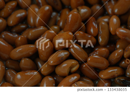 Rich and glossy brown beans nestled together, showcasing their natural sheen and earthy tones under soft lighting Rich and glossy brown beans nestled together, showcasing their natural sheen and earthy tones under soft lighting 133438035