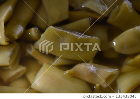 Freshly sliced green beans glistening in a savory broth, ready for a culinary masterpiece 133438043