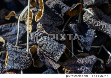 Dried chilies hanging in the sun to enhance flavor and aroma in a traditional market setting 133438044