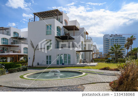 Luxury seaside villa surrounded by lush greenery with a tranquil fountain, ideal for relaxation and rejuvenation near the coast Luxury seaside villa surrounded by lush greenery with a tranquil fountain, ideal for relaxation and rejuvenation near the coast 133438068