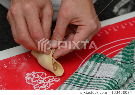 Mastering the art of dumpling making in a cozy kitchen during a culinary afternoon 133438084