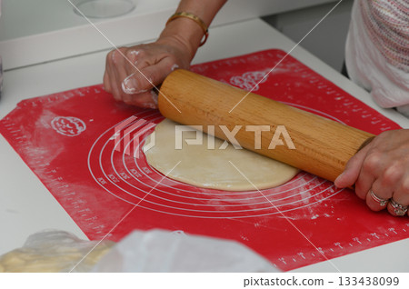 Rolling dough for a delicious homemade pastry in a bright kitchen with modern appliances and a warm atmosphere Rolling dough for a delicious homemade pastry in a bright kitchen with modern appliances and a warm atmosphere 133438099