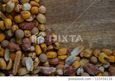 Colorful mix of nuts and seeds scattered on a wooden surface creating a vibrant texture and rustic aesthetic amid natural light Colorful mix of nuts and seeds scattered on a wooden surface creating a vibrant texture and rustic aesthetic amid natural light 133438116