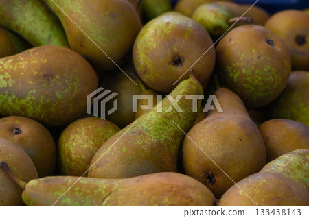 Freshly harvested pears arranged in a vibrant display at a local farmers market during autumn 133438143