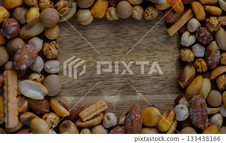 Colorful assortment of snacks encircles a wooden surface inviting a moment of sharing and enjoyment 133438166