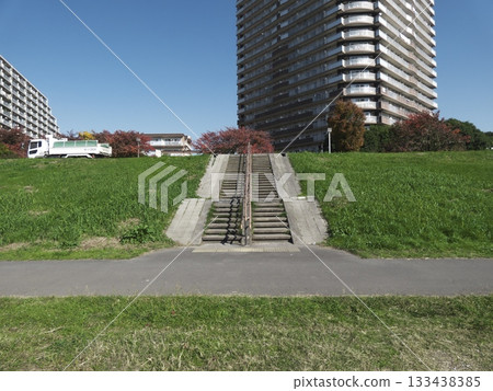 藍天之下,可以看到多摩川岸邊的台階,背後是高聳入雲的公寓大樓。 藍天之下,可以看到多摩川岸邊的台階,背後是高聳入雲的公寓大樓。 133438385