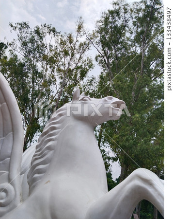 White horse statue with wings in public park, elegant decorative outdoor sculpture, artistic garden centerpiece, majestic animal figure in open green surroundings White horse statue with wings in public park, elegant decorative outdoor sculpture, artistic garden centerpiece, majestic animal figure in open green surroundings 133438497